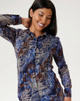 Femme portant une blouse florale bleue et brune de la nouvelle collection Linea Domani disponible chez Boutiques Marise